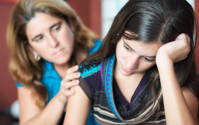 Mother comforts her teen daughter